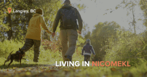 Family of three with a dog walking along a sunlit forest trail in Langley, BC, wearing outdoor gear and backpacks, with the text “LIVING IN NICOMEKL” displayed in the corner.